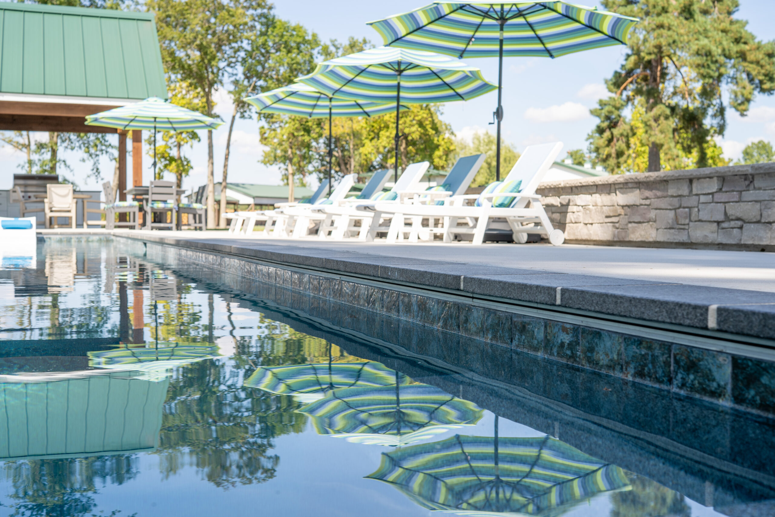 Lounge chairs on the side of a beautiful backyard pool